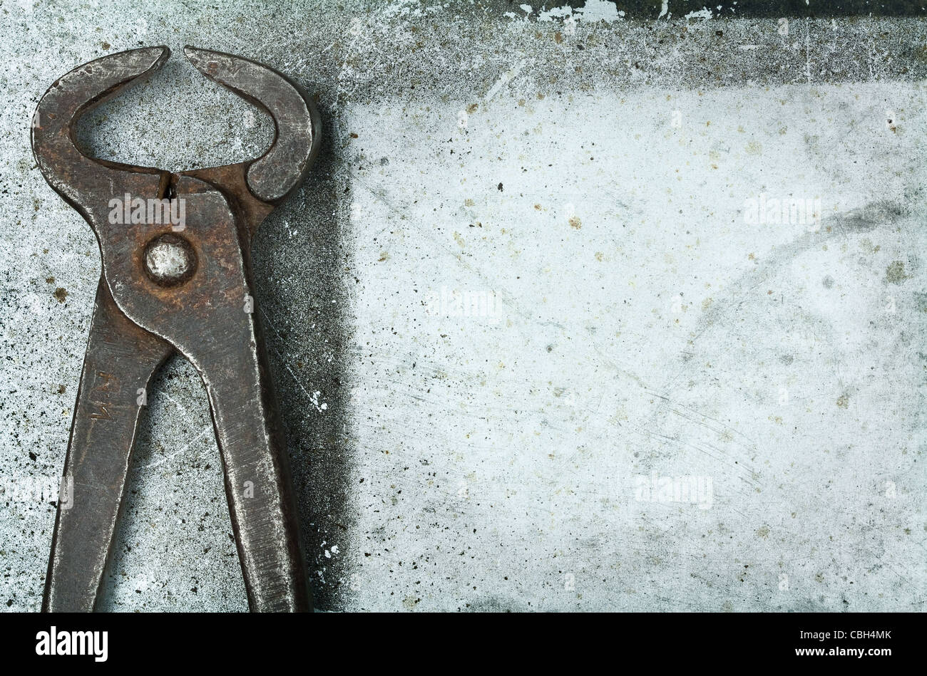 Old rusty tongs on metal background Stock Photo - Alamy