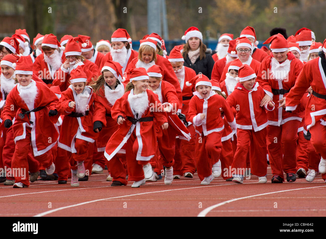 People dressed in Santa costumes taking part in a mile run to raise money for the Mary Evans Hospice in Nuneaton, Warwickshire. Stock Photo