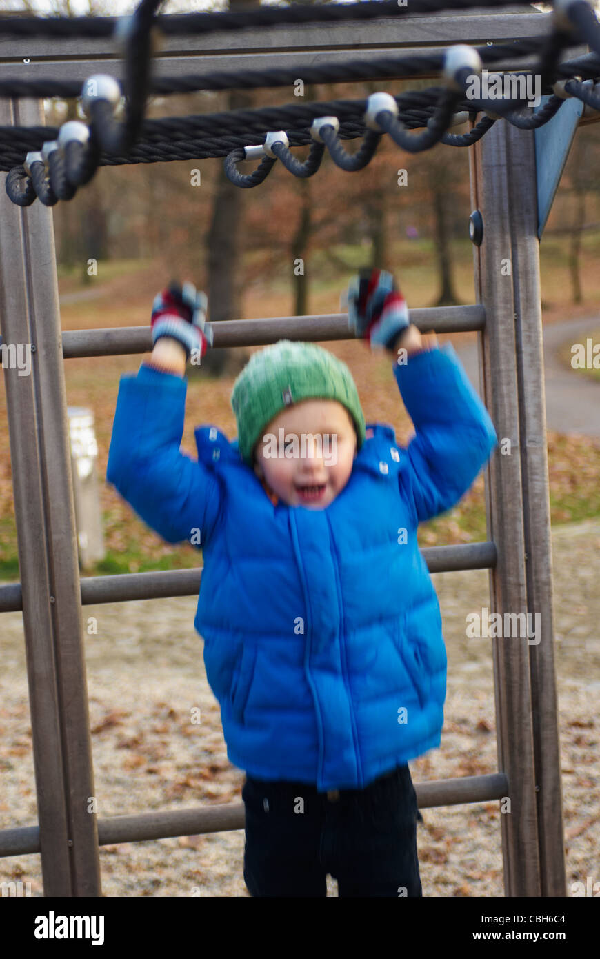 A child blond boy 5 years on a playground, rope net, slide, accident ...