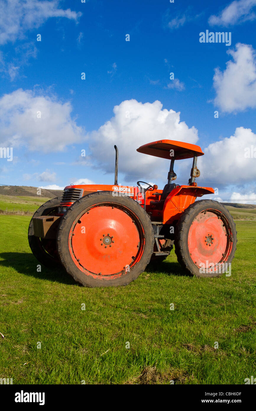 Big Red Tractor in green hills pretty clouds Stock Photo Alamy