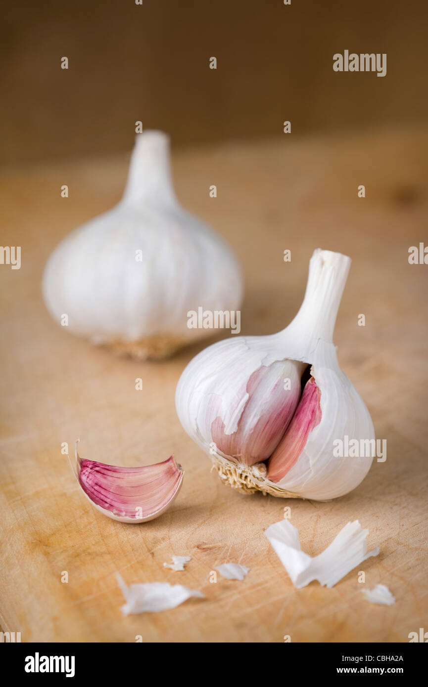 garlic bulbs and cloves on a wooden chopping board Stock Photo