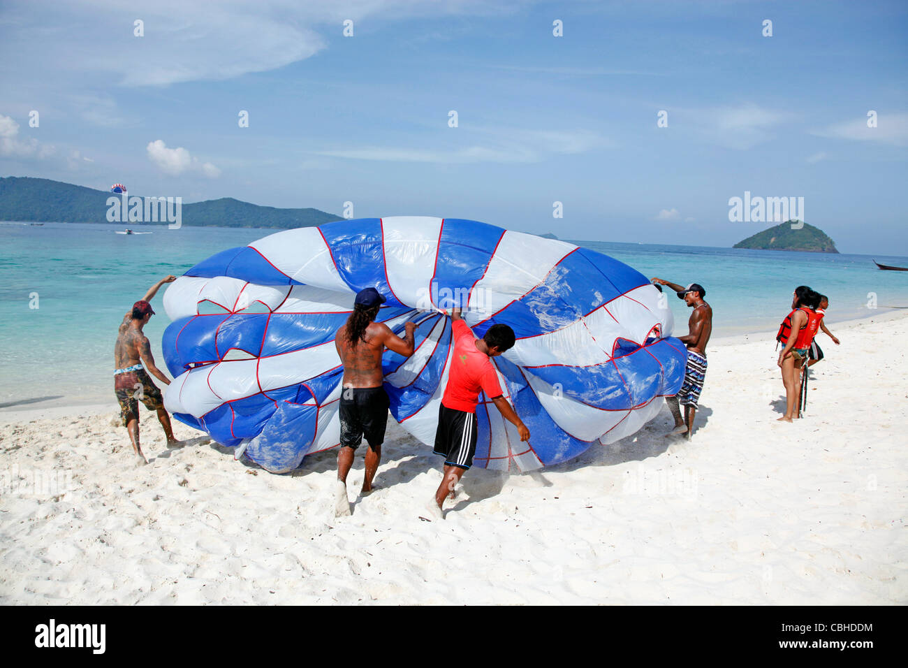 Tourists enjoying sport activities, parasailing with a speedboat and parachute on Coral Island, Phuket, Thailand Stock Photo