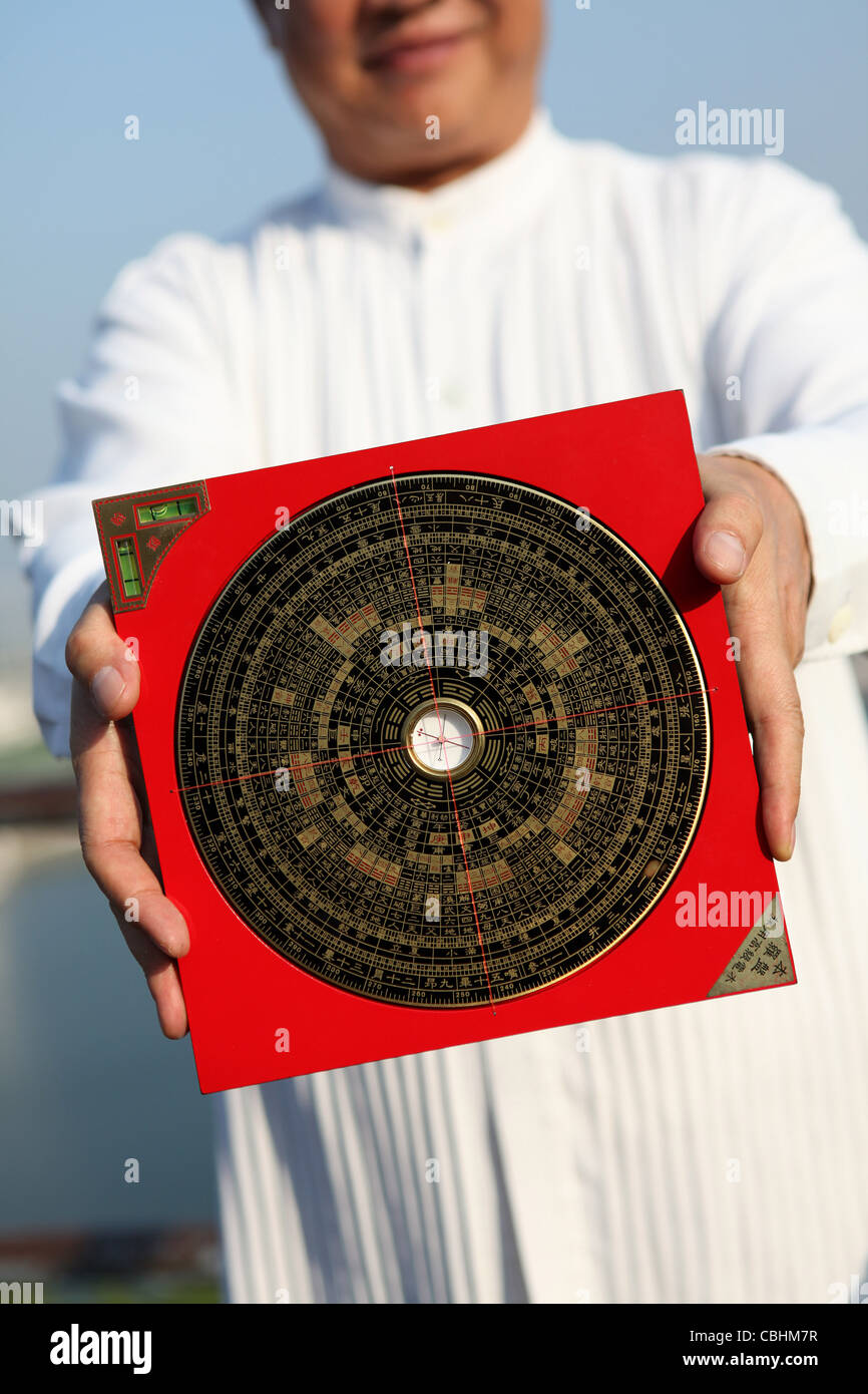 Feng Shui master holding a Compass Stock Photo