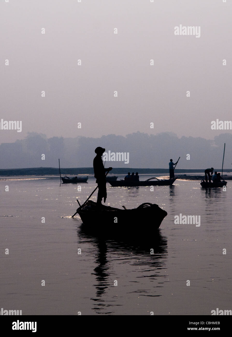 An Indian fisherman rowing his boat during sunrise on the Gandak river in Bihar. Stock Photo