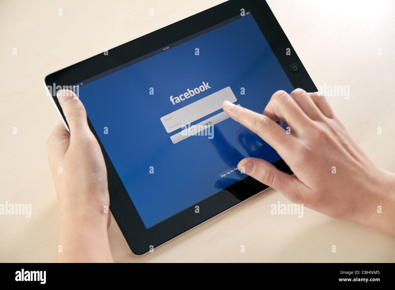 Facebook launch application for iPad in October 10, 2011. Girl trying to log in using Apple iPad2. Stock Photo