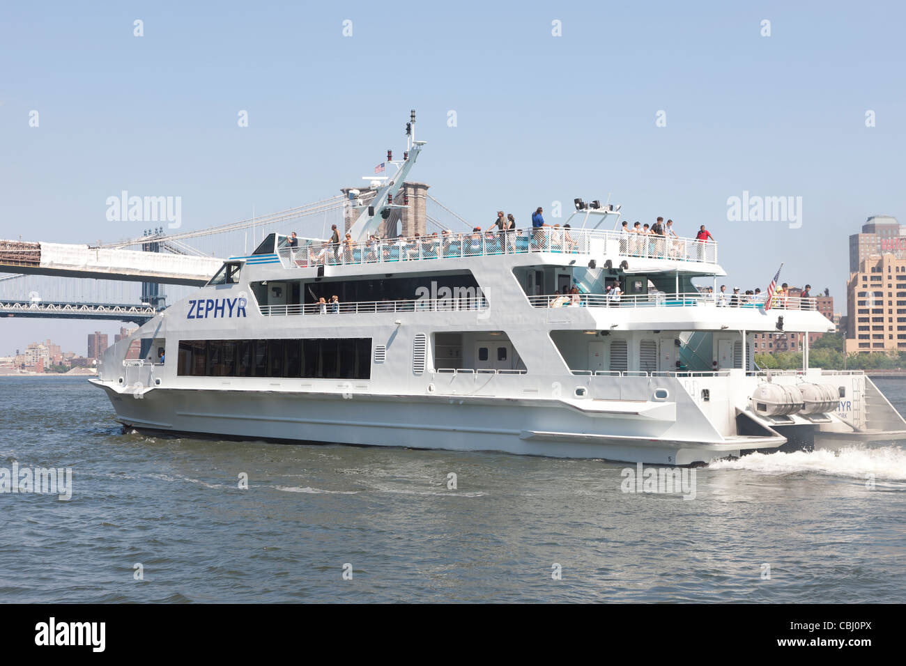 The Circle Line Zephyr departs South Street Seaport Pier 16 with a load of passengers in New York City. Stock Photo