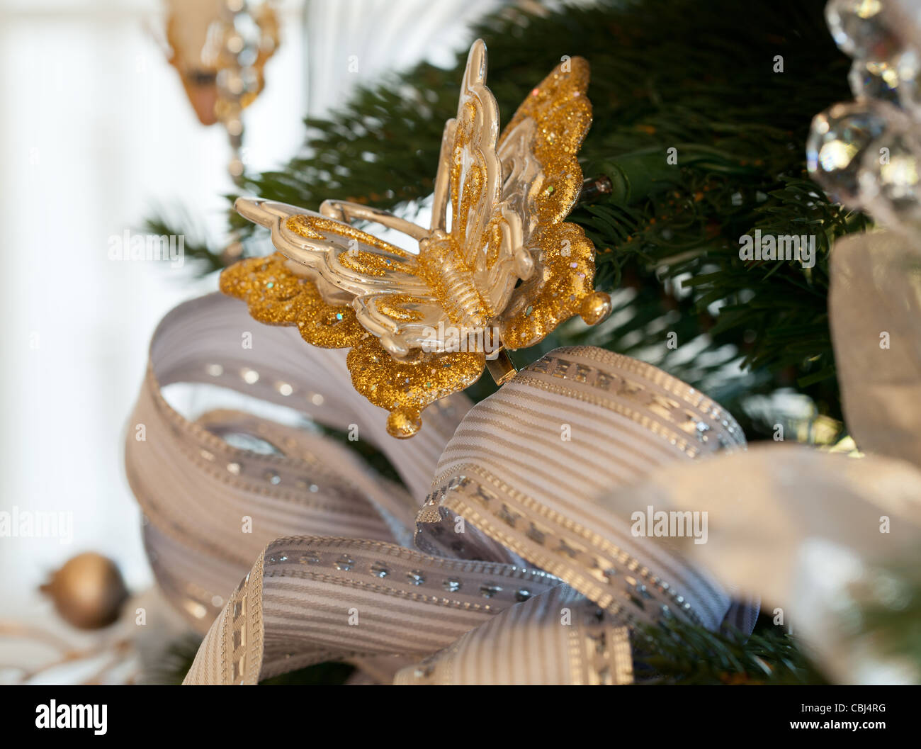https://c8.alamy.com/comp/CBJ4RG/christmas-tree-decorated-with-silver-and-white-ribbons-and-butterfly-CBJ4RG.jpg