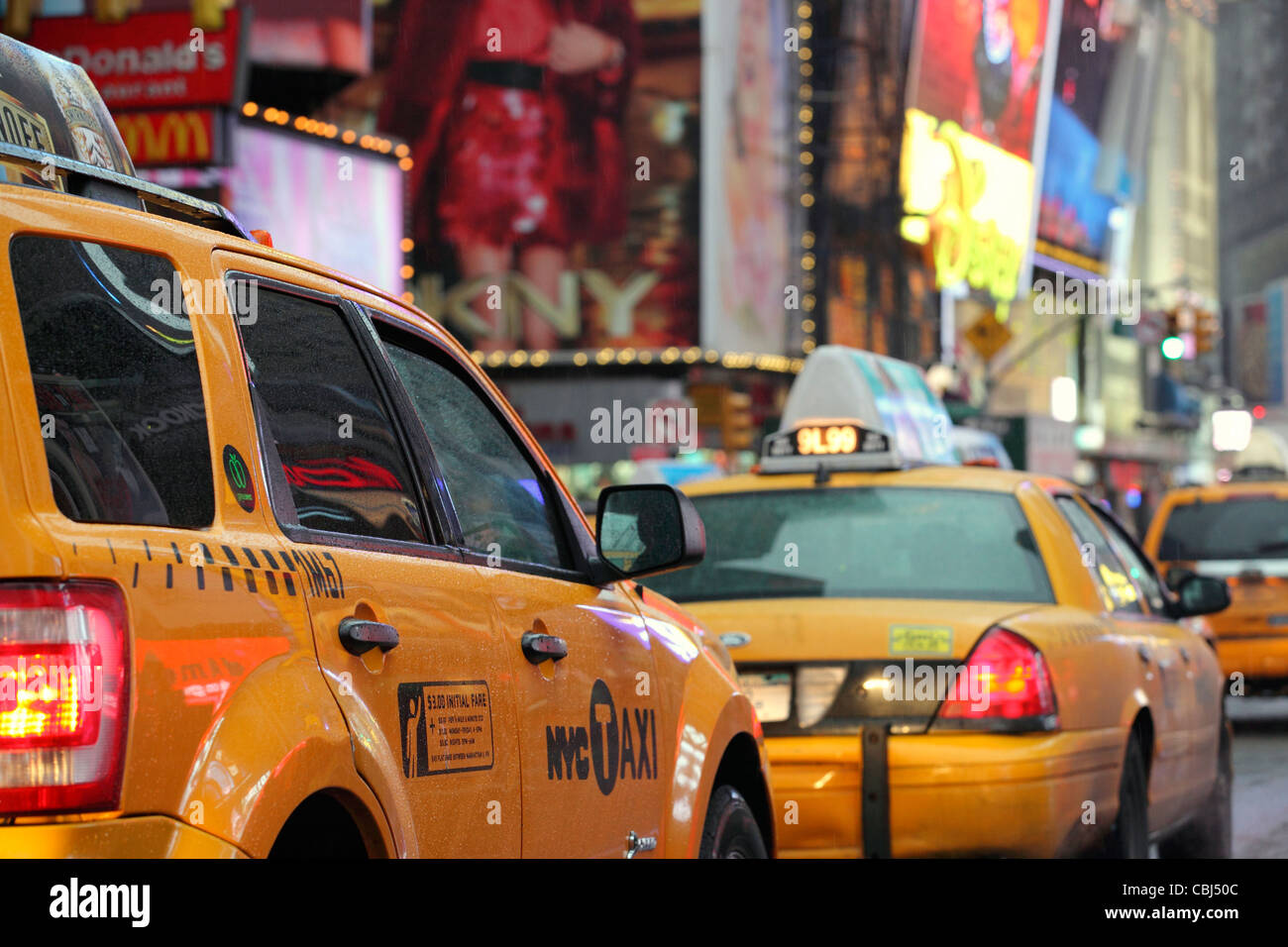 rear view of iconic yellow taxi cabs queuing on Broadway going through Times Square, Manhattan, New York City, NYC, USA Stock Photo
