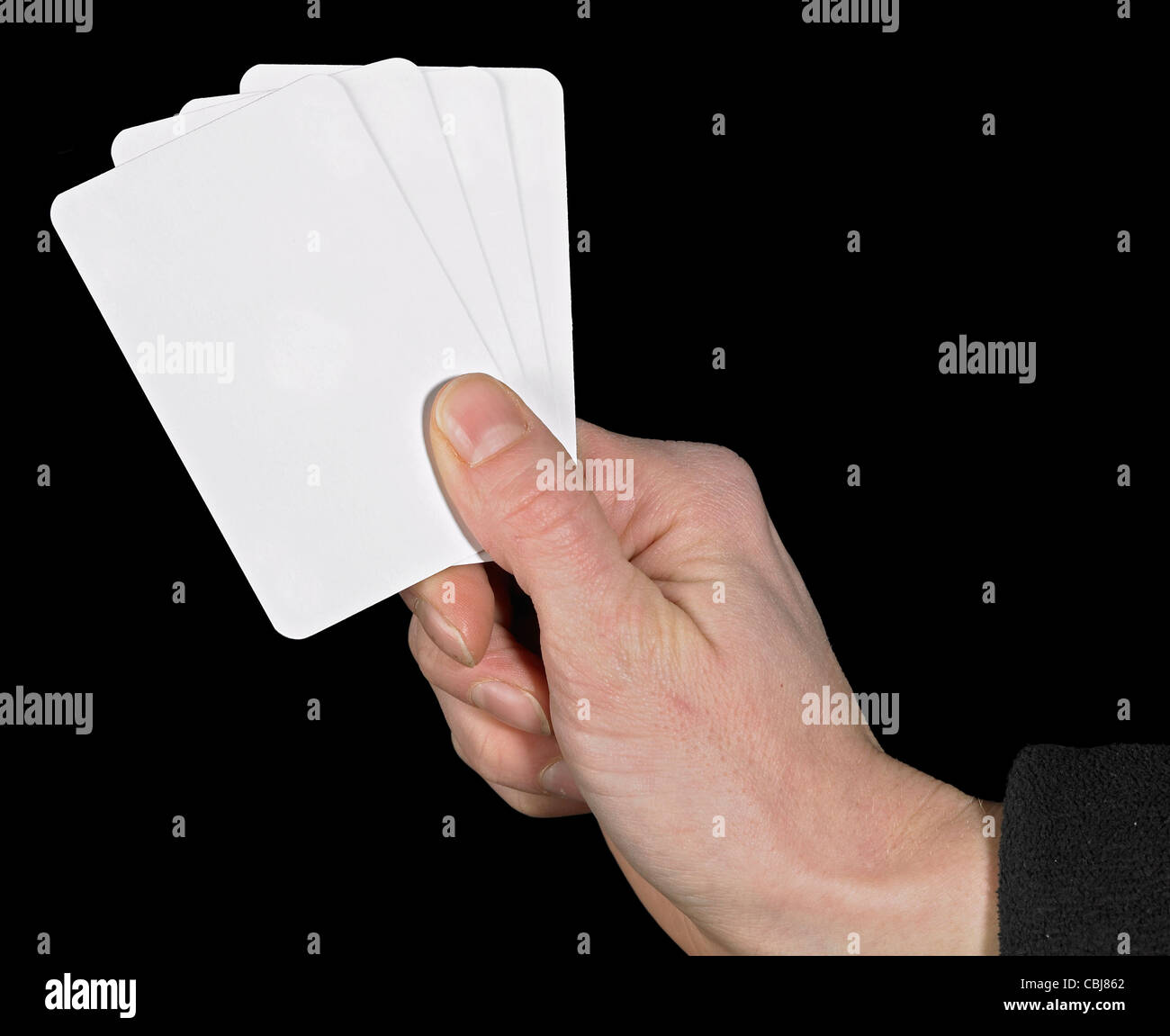 studio photography of a hand and white playing cards in dark back Stock Photo