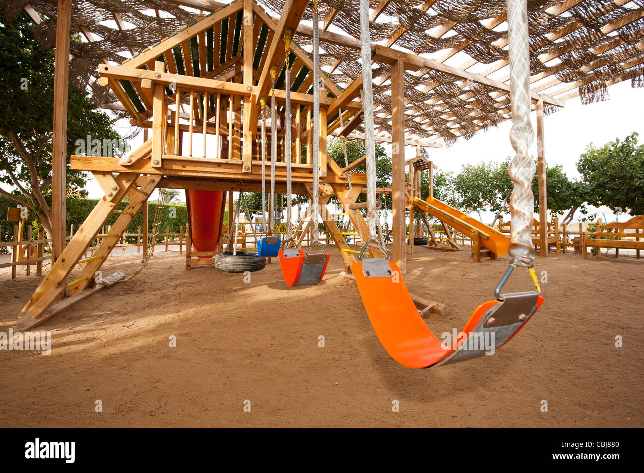 Childrens wooden climbing frame with slide in a playground at park