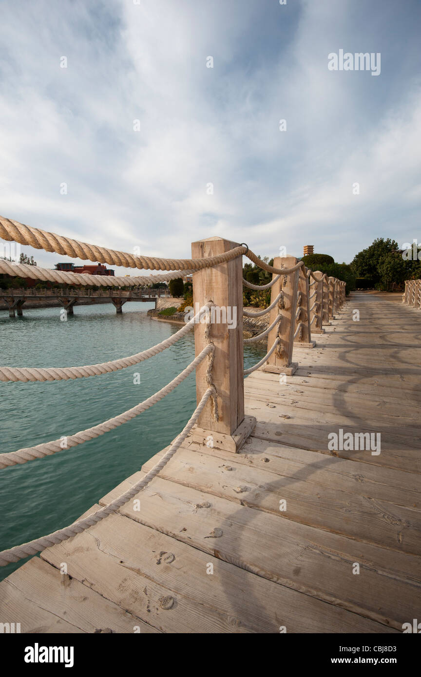 Bridge Rope Over Water Wooden bridge with rope handrails over water at a tropical resort with ...