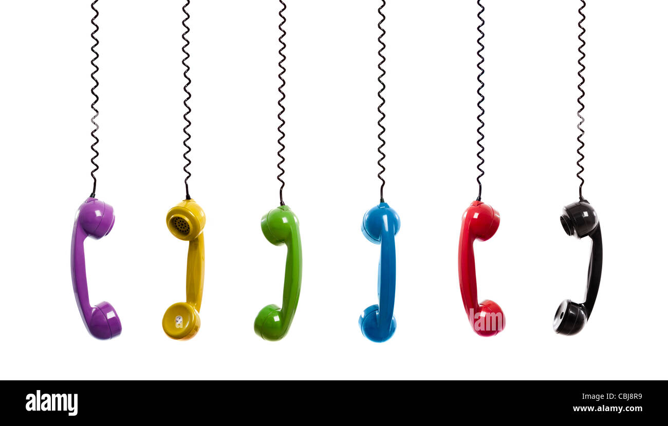 Multi colored handset pieces suspended by the phone cord, isolated on white background Stock Photo