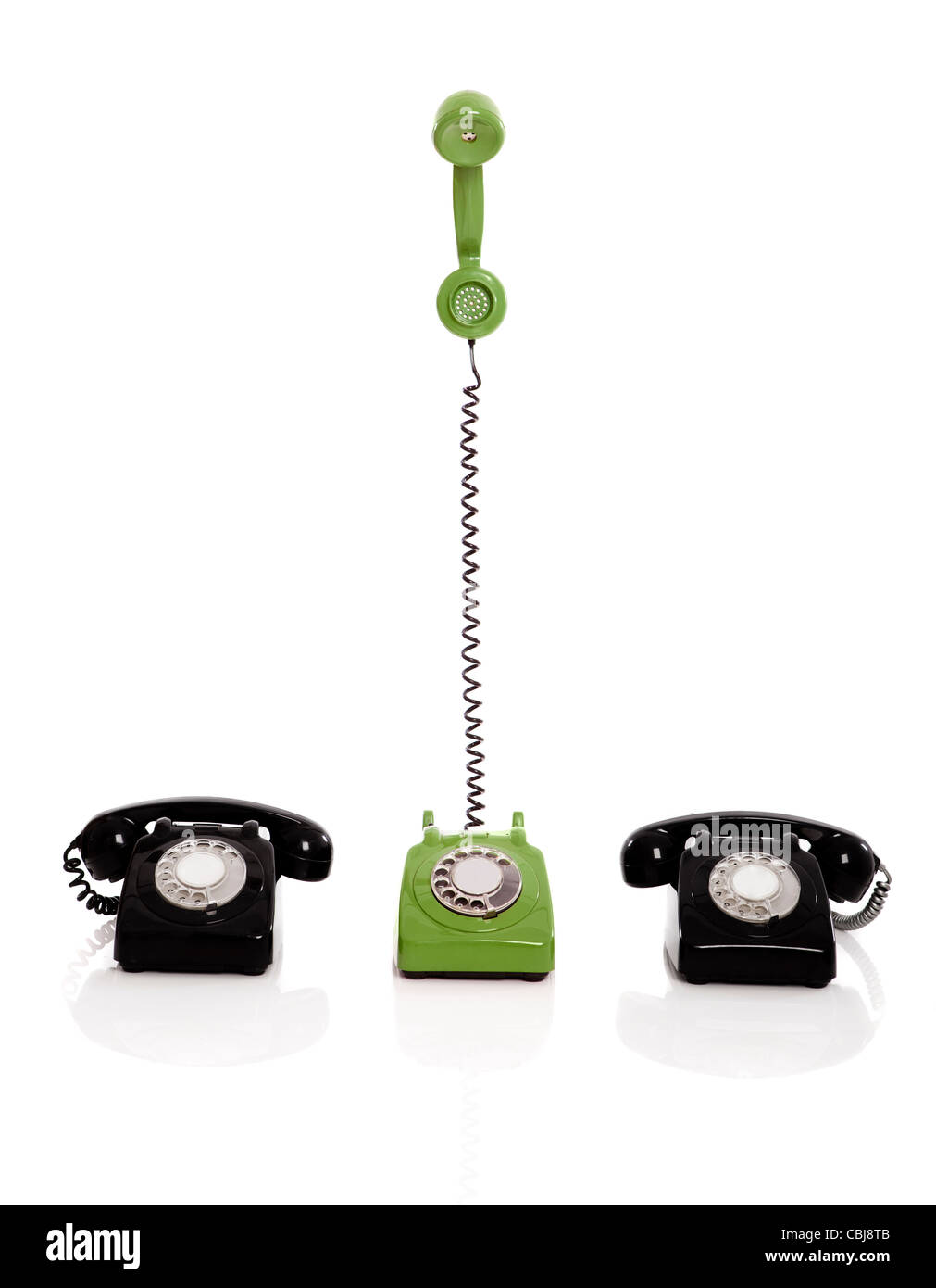 Green phone ringing in the middle of two black phones, isolated on ...