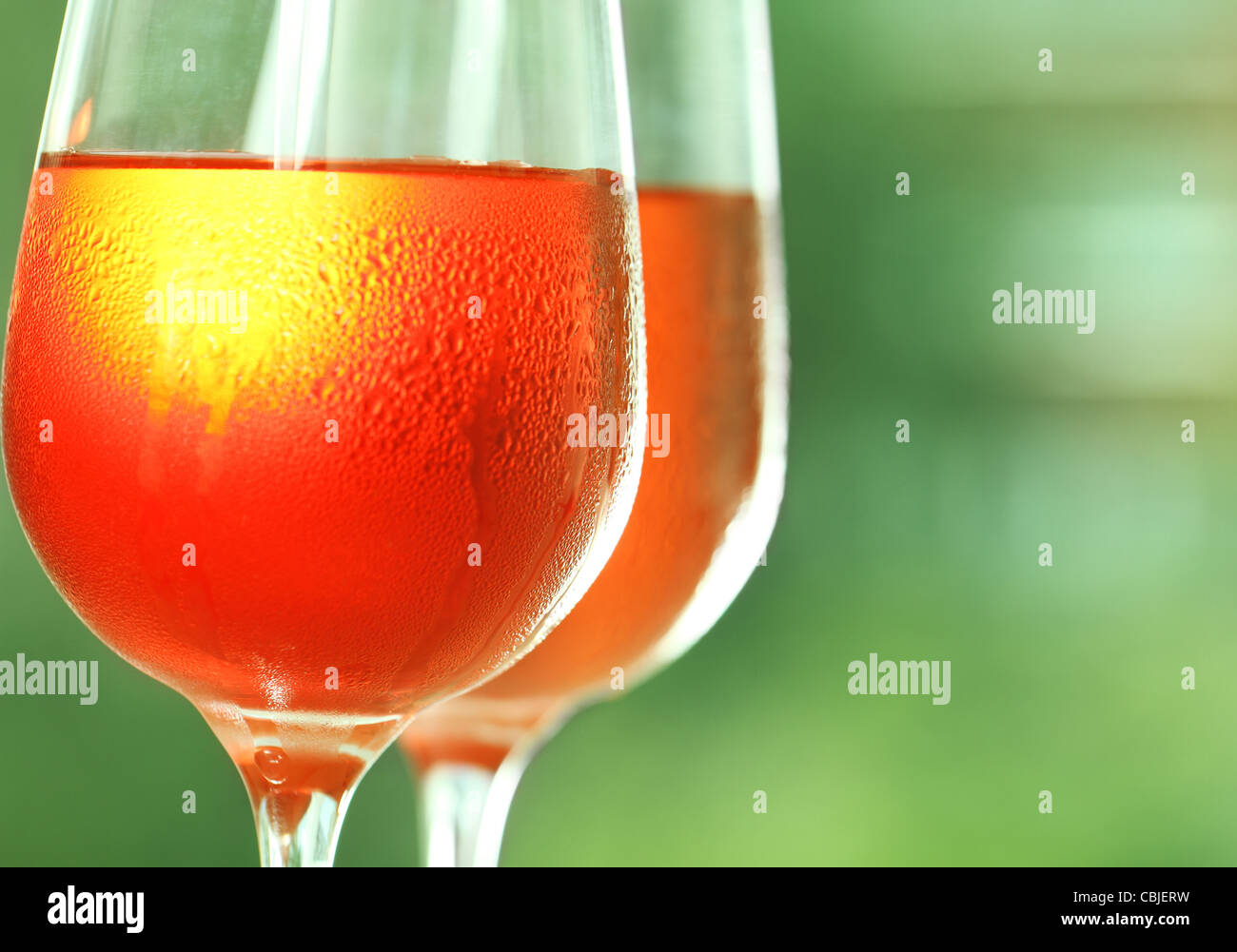 Two glasses of a rose wine against green background Stock Photo - Alamy