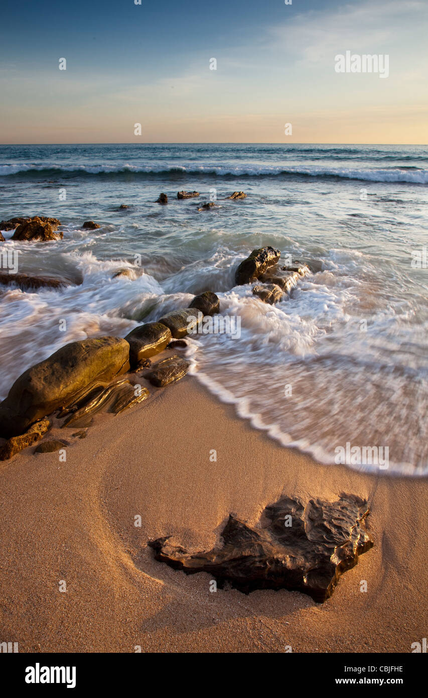 Rocky beach at sunset Stock Photo - Alamy