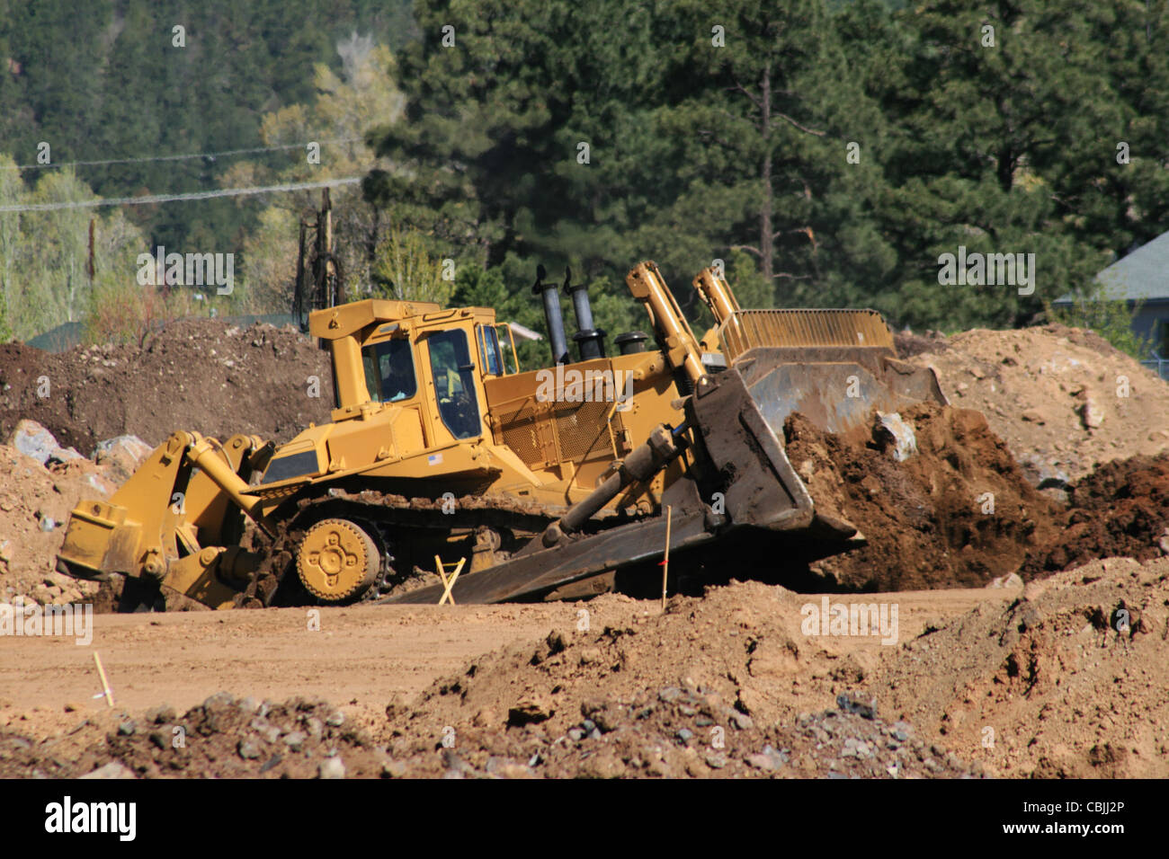 large yellow bulldozer moves soil at a construction site Stock Photo
