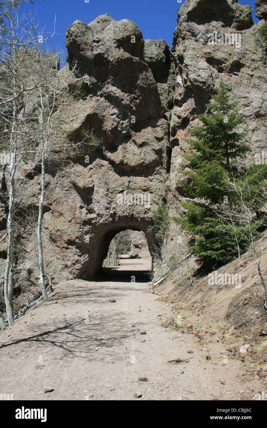 tunnel through a rock outcrop for a single lane dirt road Stock Photo