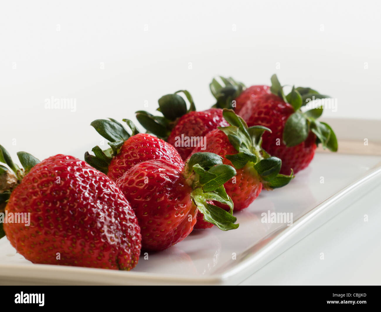 Fresh ripe strawberries on long white plate Stock Photo - Alamy