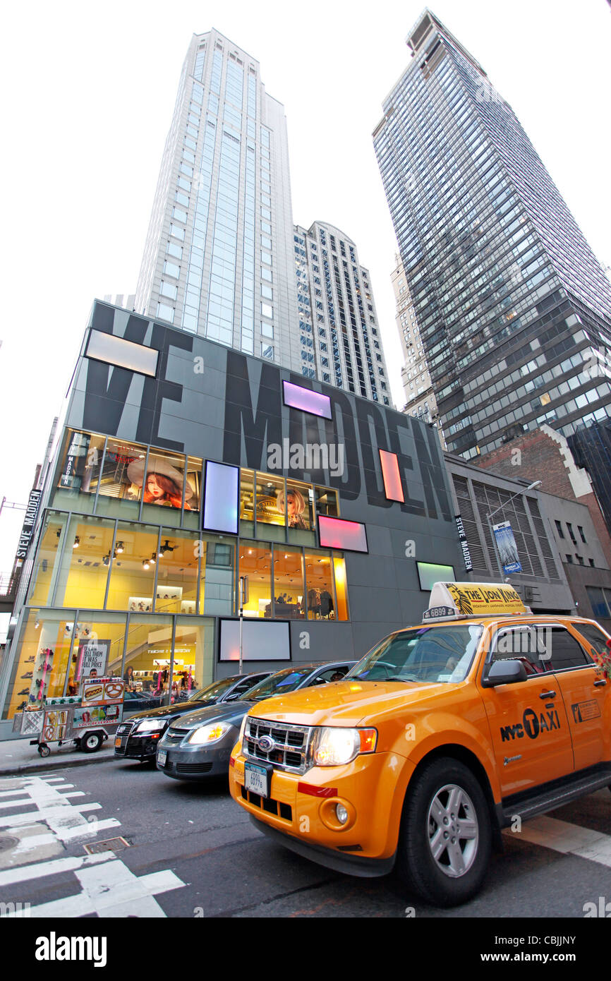 Yellow New York taxi cab in front of tall office blocks and skyscrapers