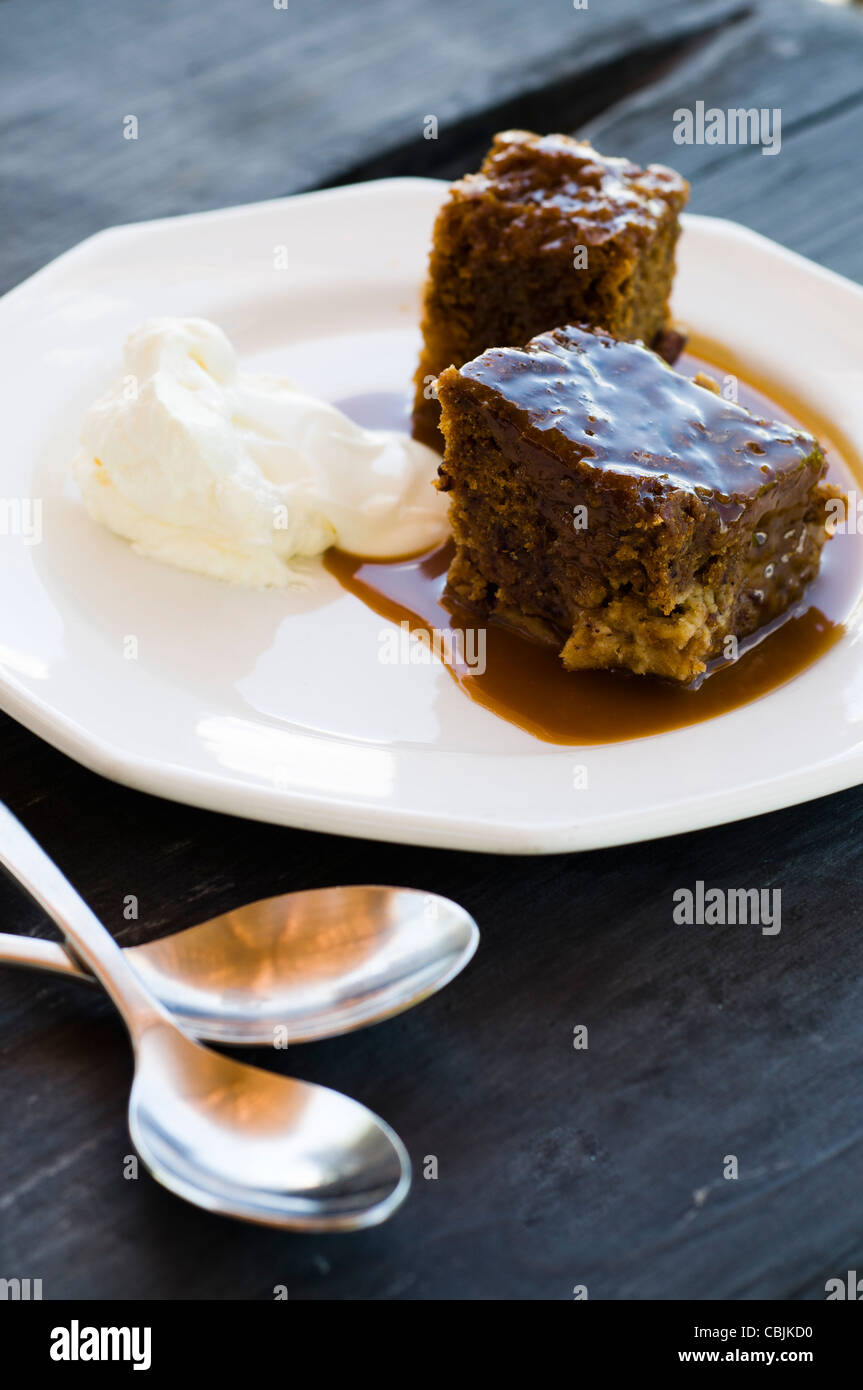 sticky toffee pudding with ice cream and spoons Stock Photo Alamy