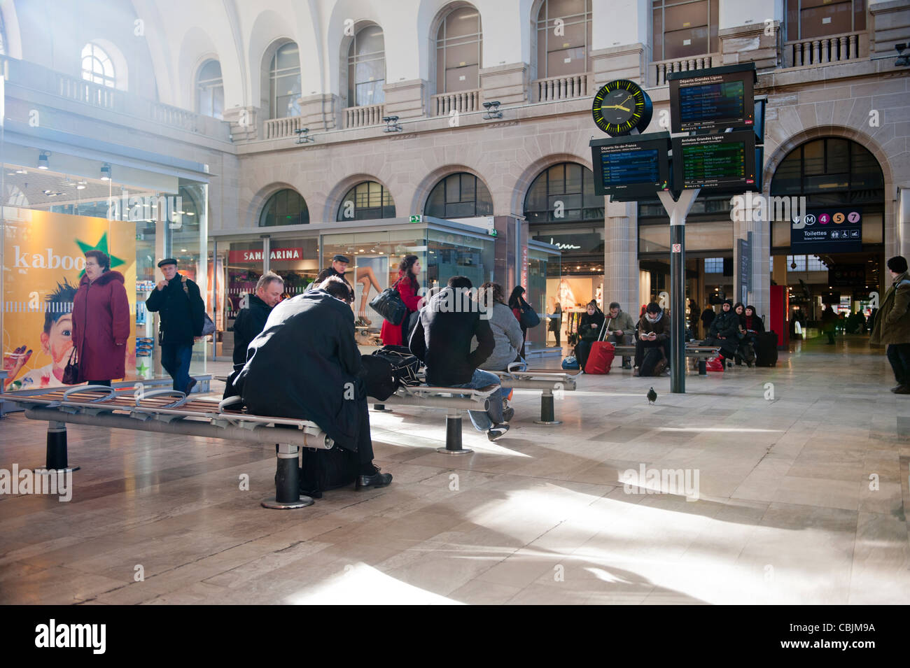 People sitting in a waiting area in the Gare de l'est train rail railway station in Paris, France. Stock Photo