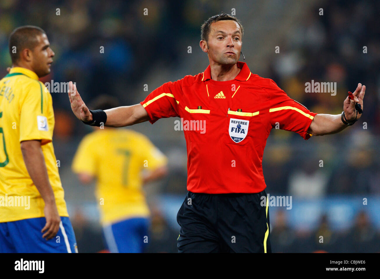 Referee Stephane Lannoy gestures to caution a player during a 2010 FIFA World Cup match between Cote d'Ivoire and Brazil. Stock Photo
