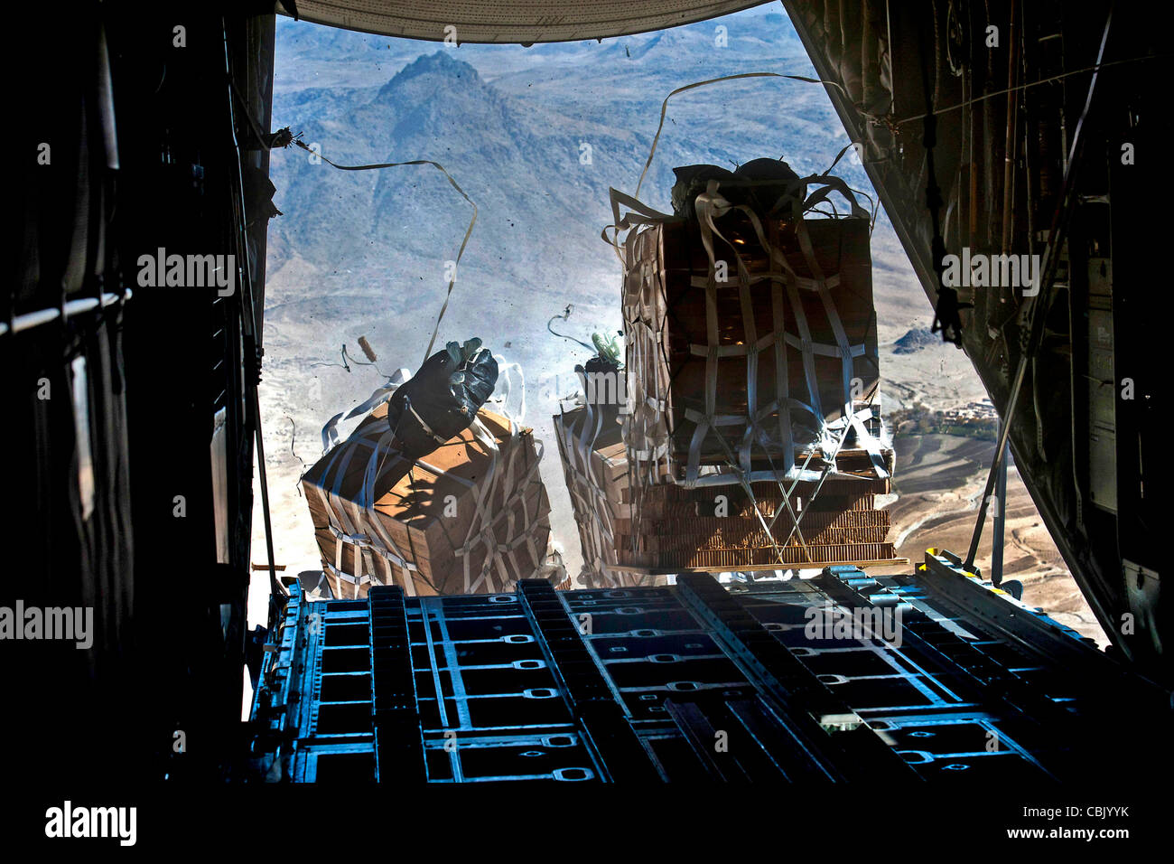 Crews drop pallets supplies from a U.S. Air Force C-130 Hercules aircraft over Bagram Airfield in Kandahar, Afghanistan Stock Photo