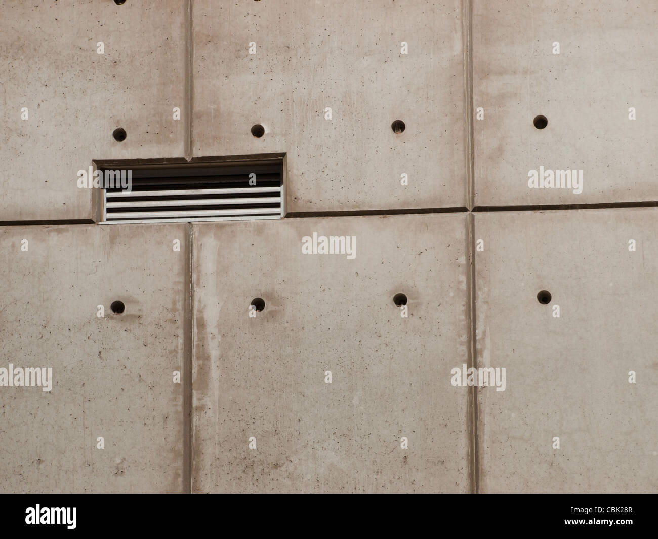 Raw concrete wall background with formwork lines and tie hole plugs