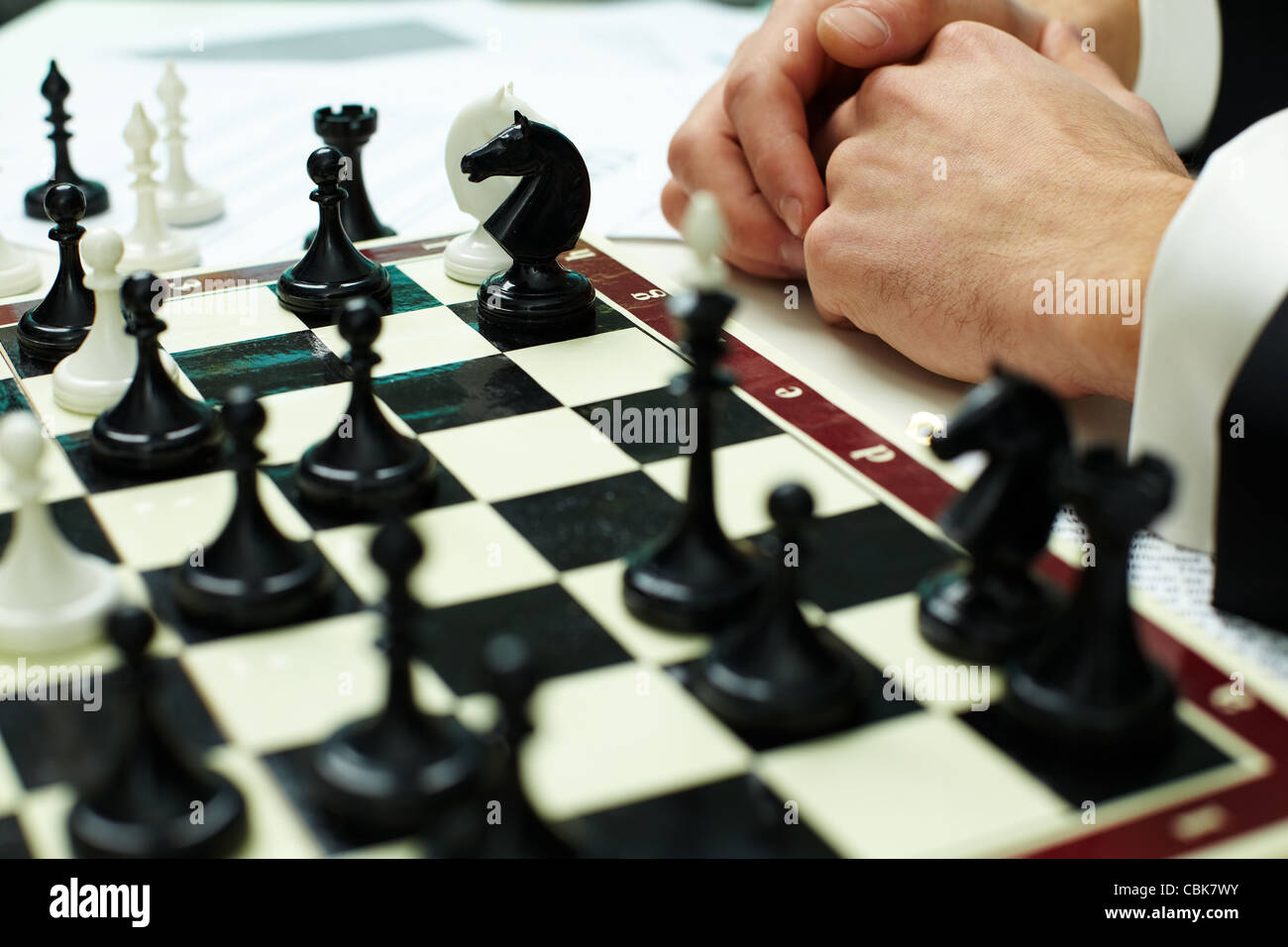 Image of chess figures on chessboard with human hands near by Stock Photo