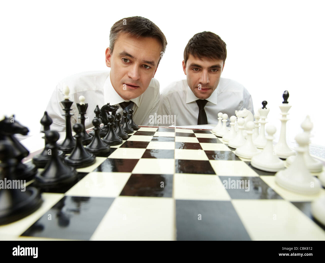 Two men looking at chess figures on chess board Stock Photo