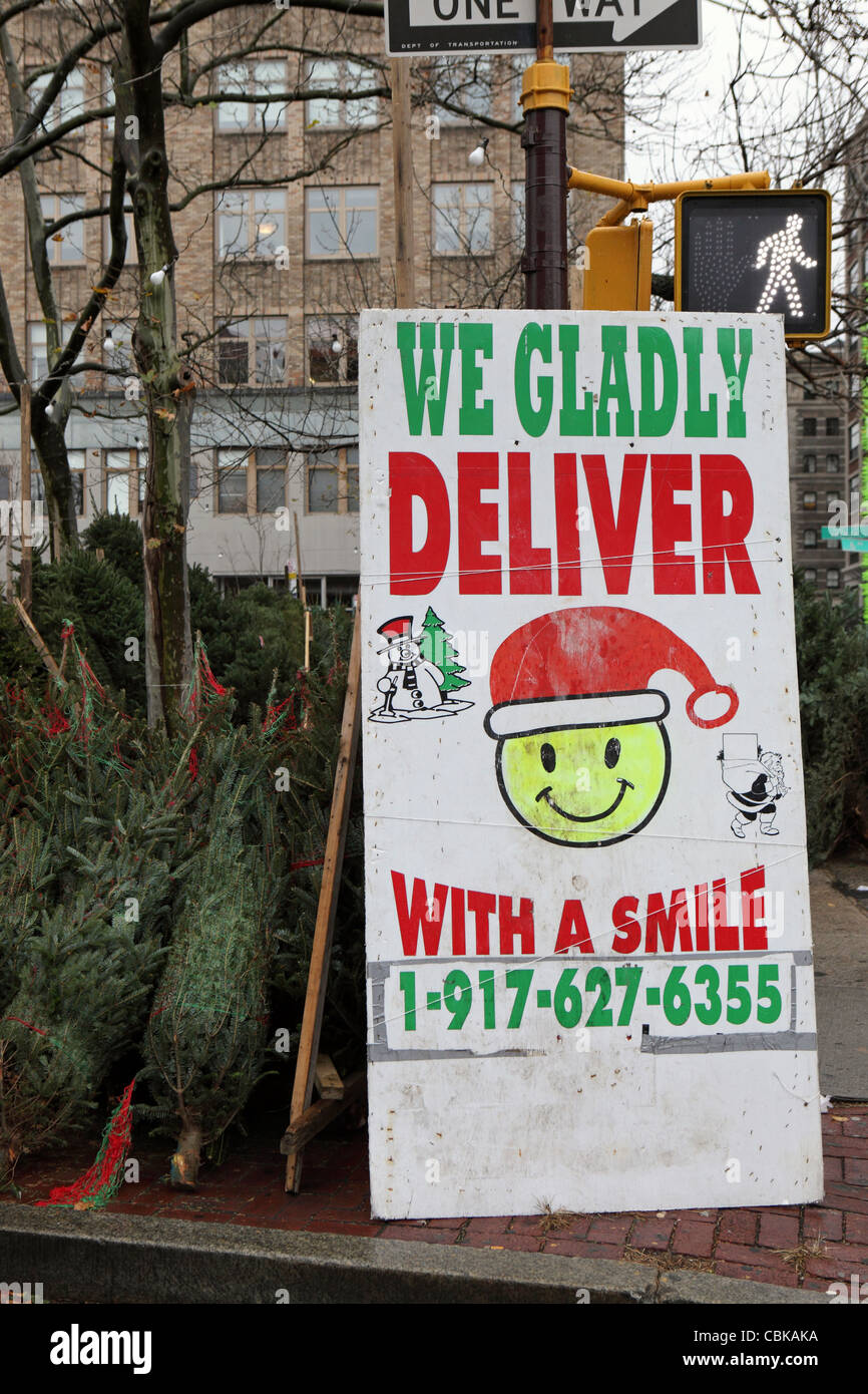 Street side Christmas tree seller, Lower Manhattan, sign reads 'We Gladly Deliver, with a smile', New York City, NYC, USA Stock Photo