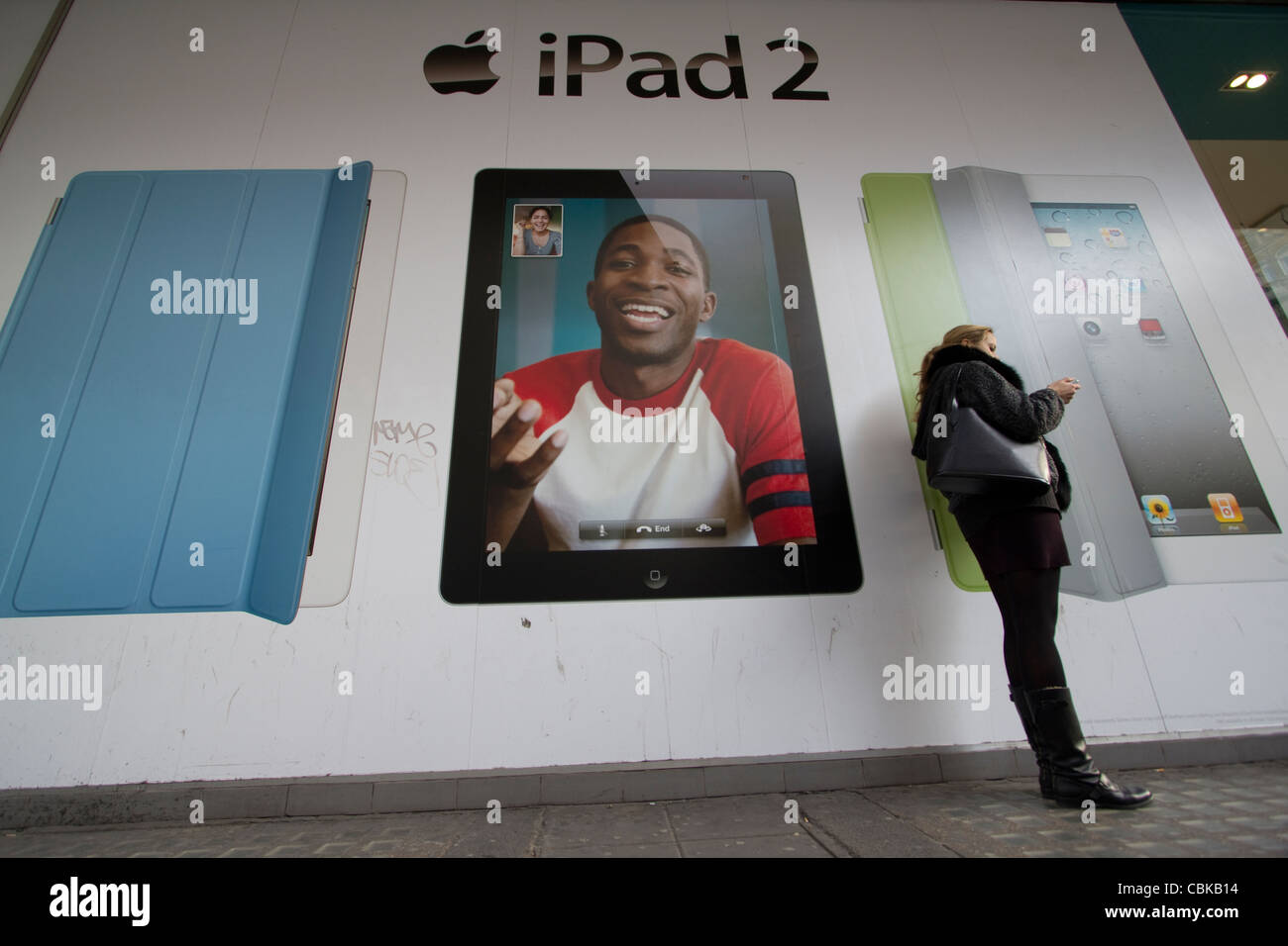 ipad 2, Advertisement, billboard for IPad2 Central London, with shopper using phone in foreground Stock Photo