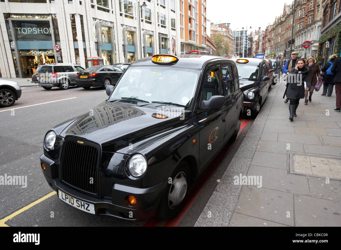 row of black london cabs taxis for hire on knightsbridge shopping street in central london england united kingdom uk Stock Photo