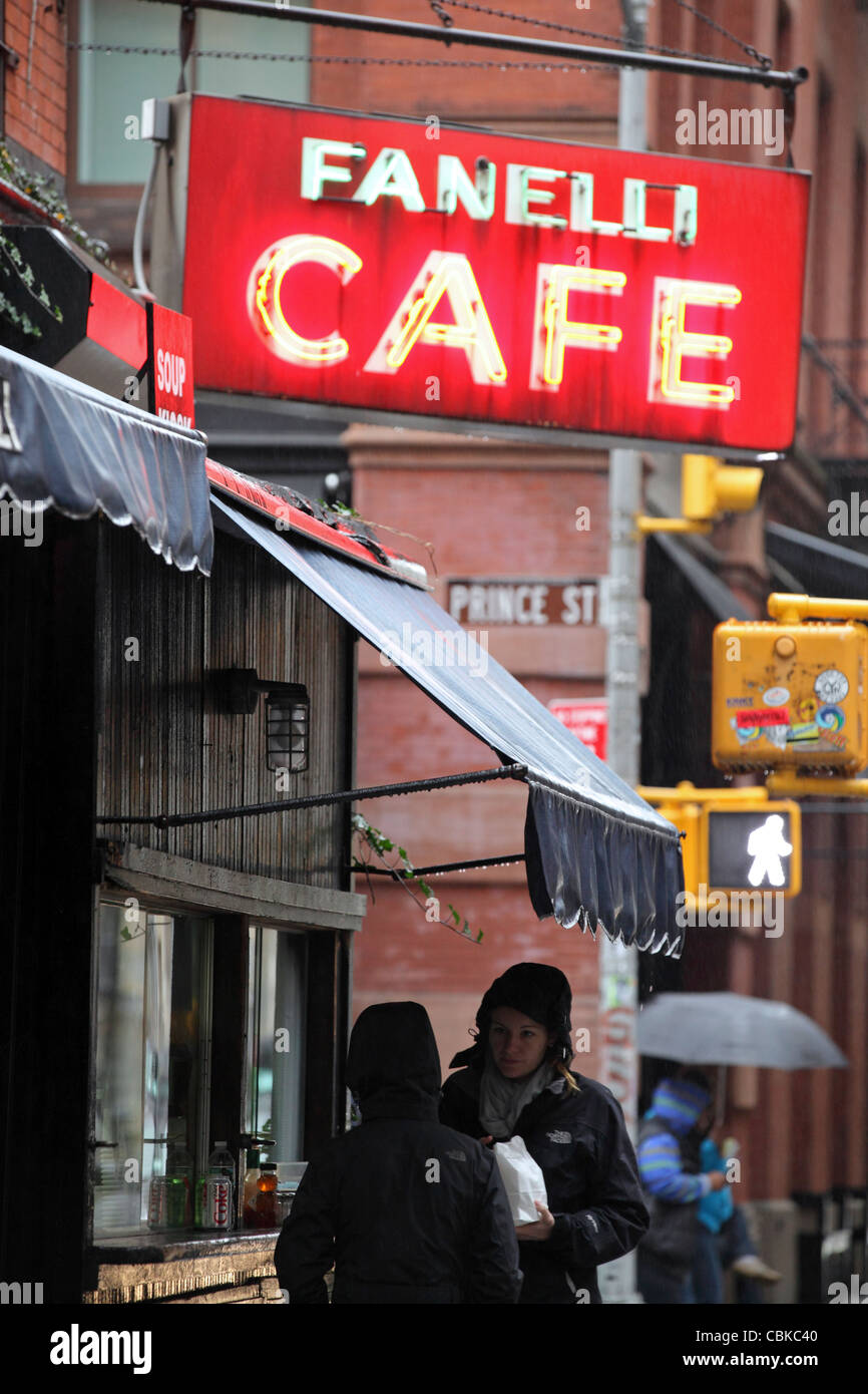 customers buying takeaway food under, illuminated neon sign 'Fanelli Cafe', SoHo, Manhattan, New York City, NYC, USA Stock Photo