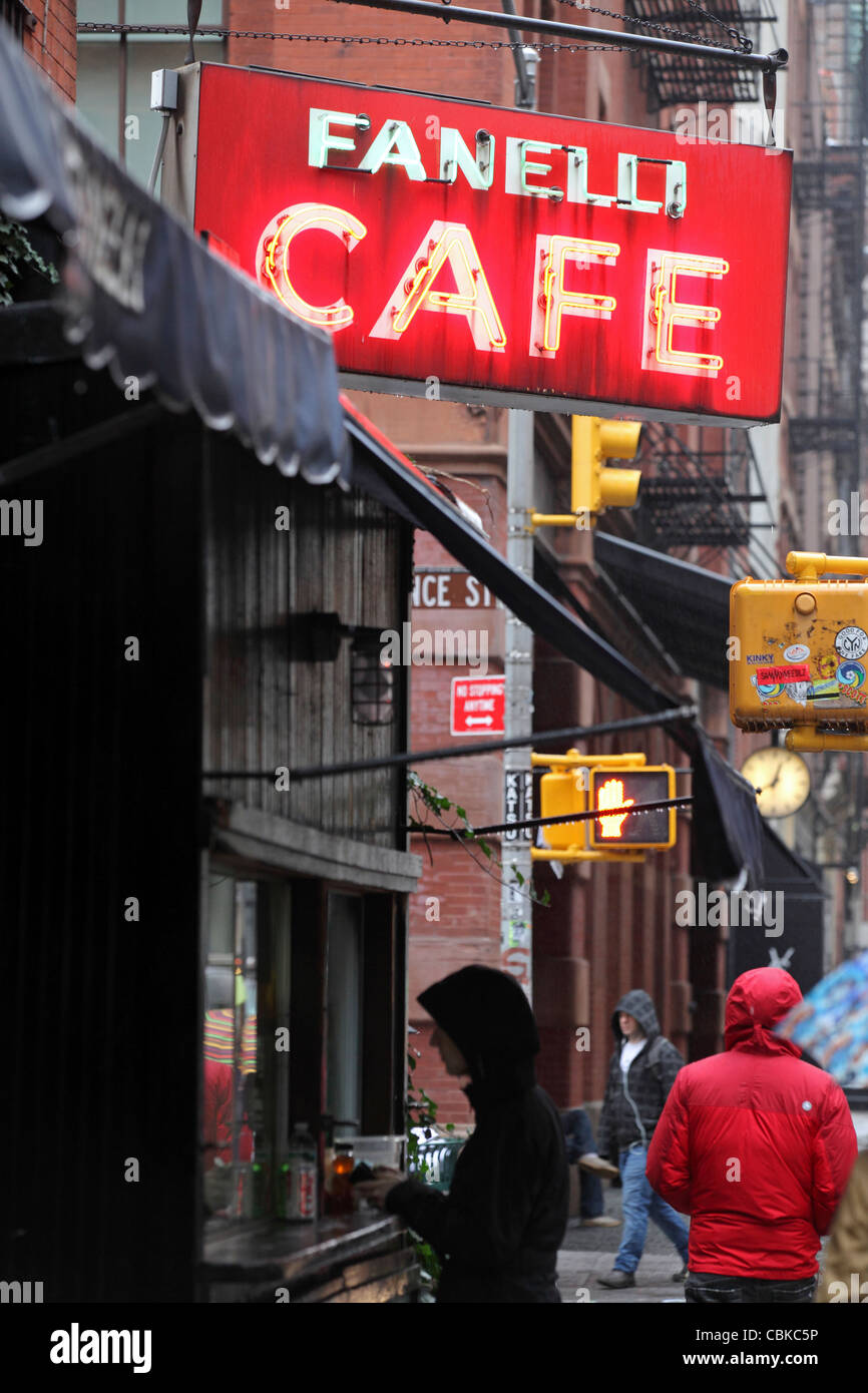 customer buying takeaway food under, illuminated neon sign 'Fanelli Cafe', SoHo, Manhattan, New York City, NYC, USA Stock Photo
