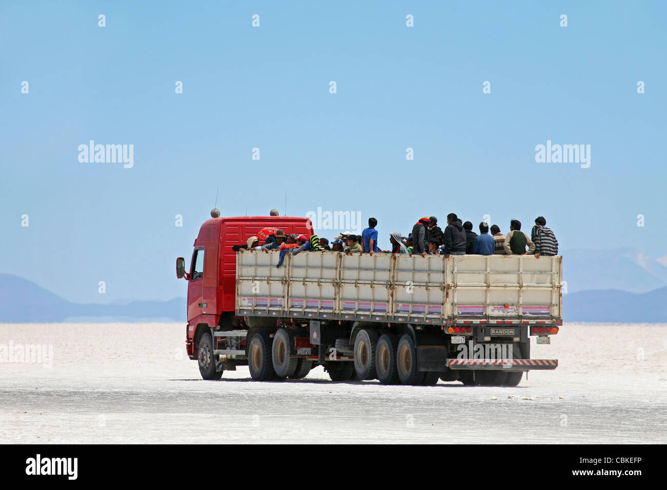 Truck with school children on the salt flat Salar de Uyuni, Altiplano, Bolivia Stock Photo