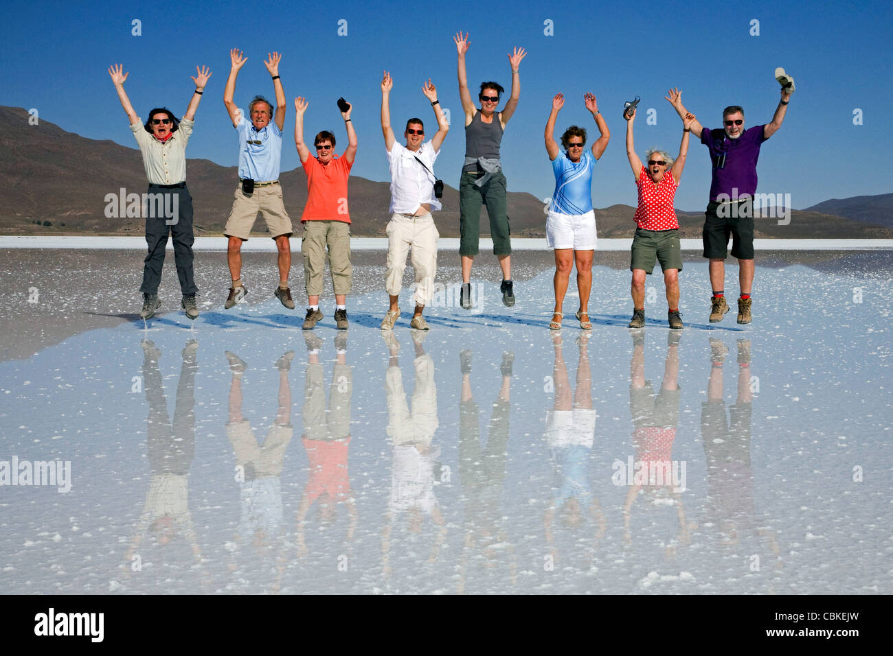 Tourists posing for camera while jumping in the air on the salt flat Salar de Uyuni, Altiplano, Bolivia Stock Photo