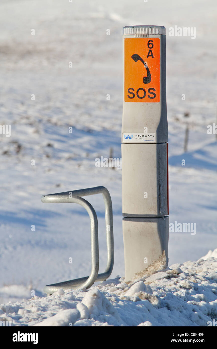 Highways Agency emergency telephone point set against a snowy landscape on the Woodhead Pass in Yorkshire Stock Photo