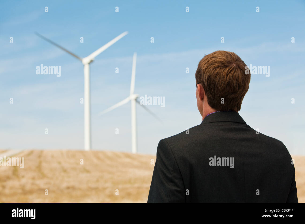 Young man watching wind turbines Stock Photo