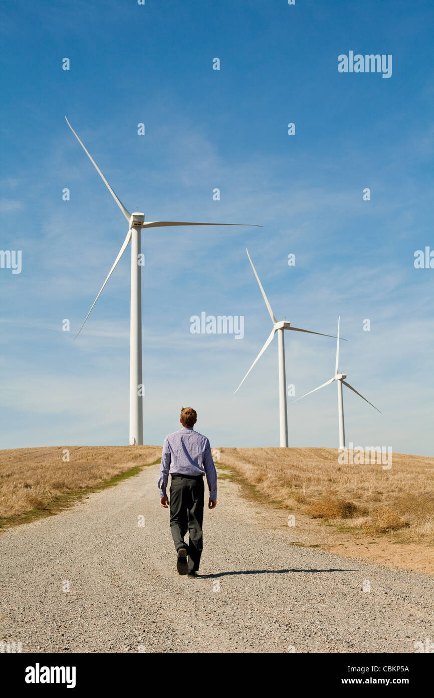 Man walking towards wind turbines Stock Photo
