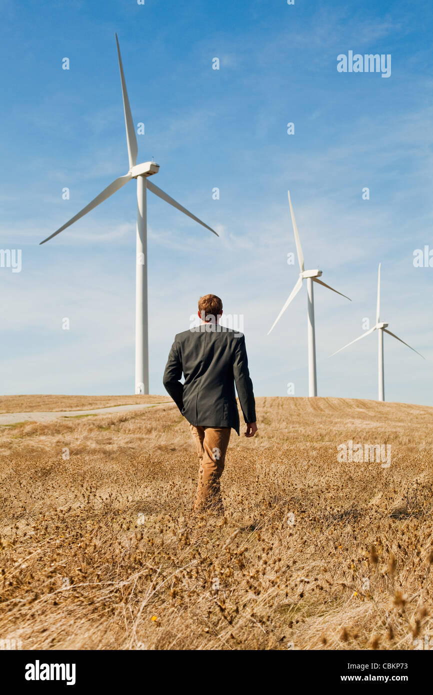 Man walking in front of wind turbines Stock Photo