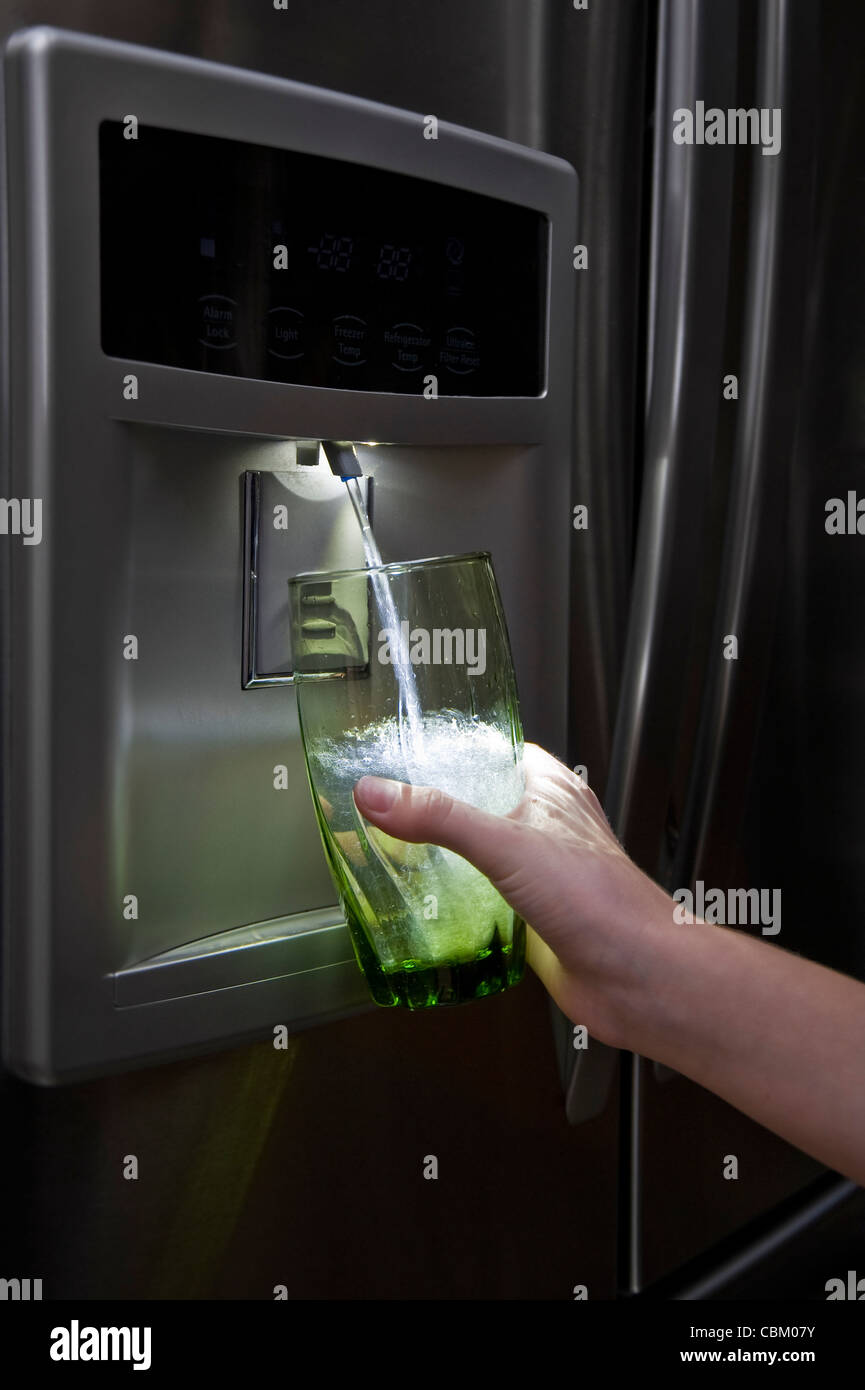 Filtered Drinking Water Being Dispensed From Refrigerator, USA Stock Photo
