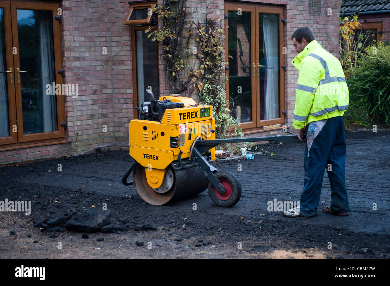 man using vibrating roller Stock Photo Alamy