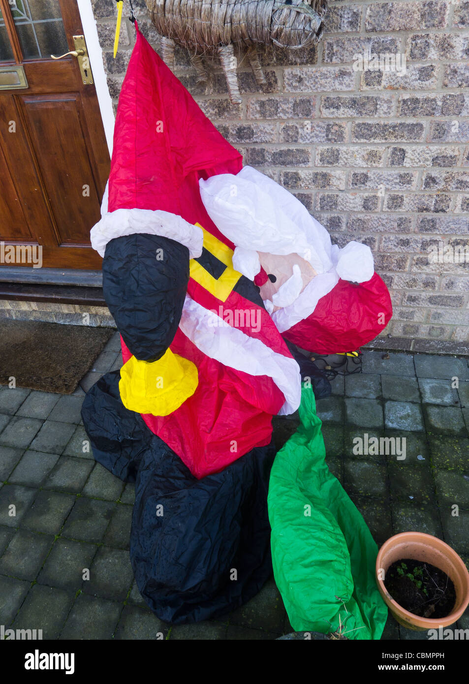 Inflatable Father Christmas deflated. Stock Photo