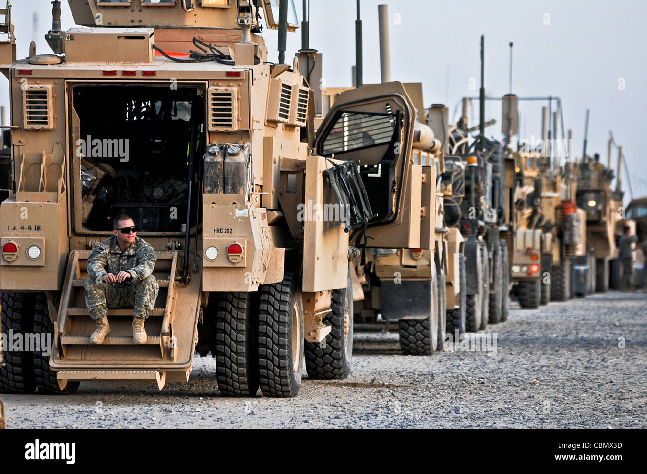 A US Army soldier with the 82nd Airborne Division sits on the stairs of his mine-resistant, ambush-protected vehicle while crossing the Khabari border from Iraq into Kuwait December 9, 2011 as part of the final US withdraw of forces from Iraq.The US is completing their 8-year mission in Iraq Stock Photo