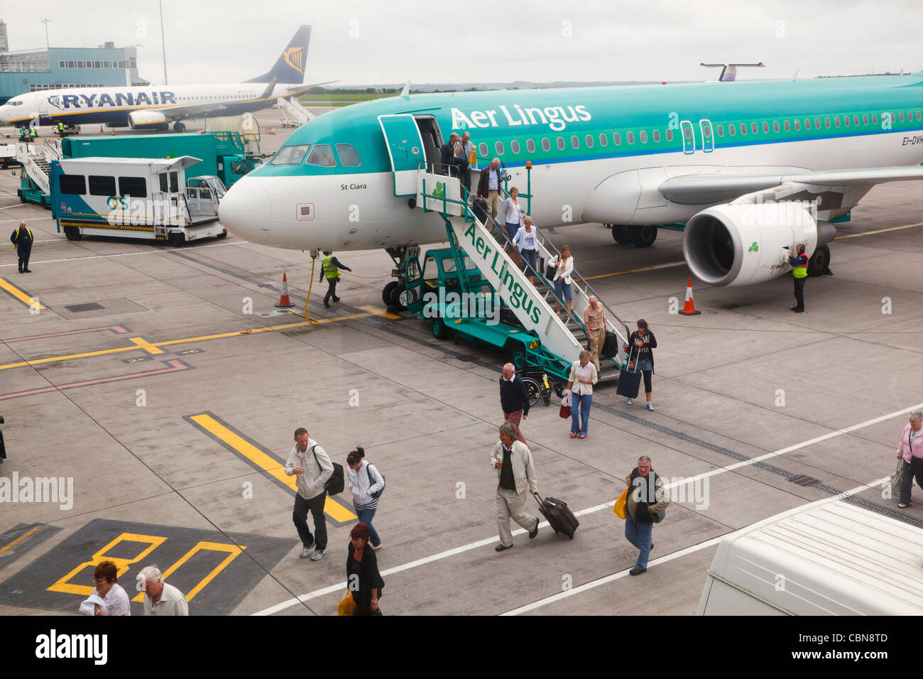 Passengers disembarking from Aer Lingus plane on apron of Cork airport. County Cork, Republic of Ireland. Stock Photo