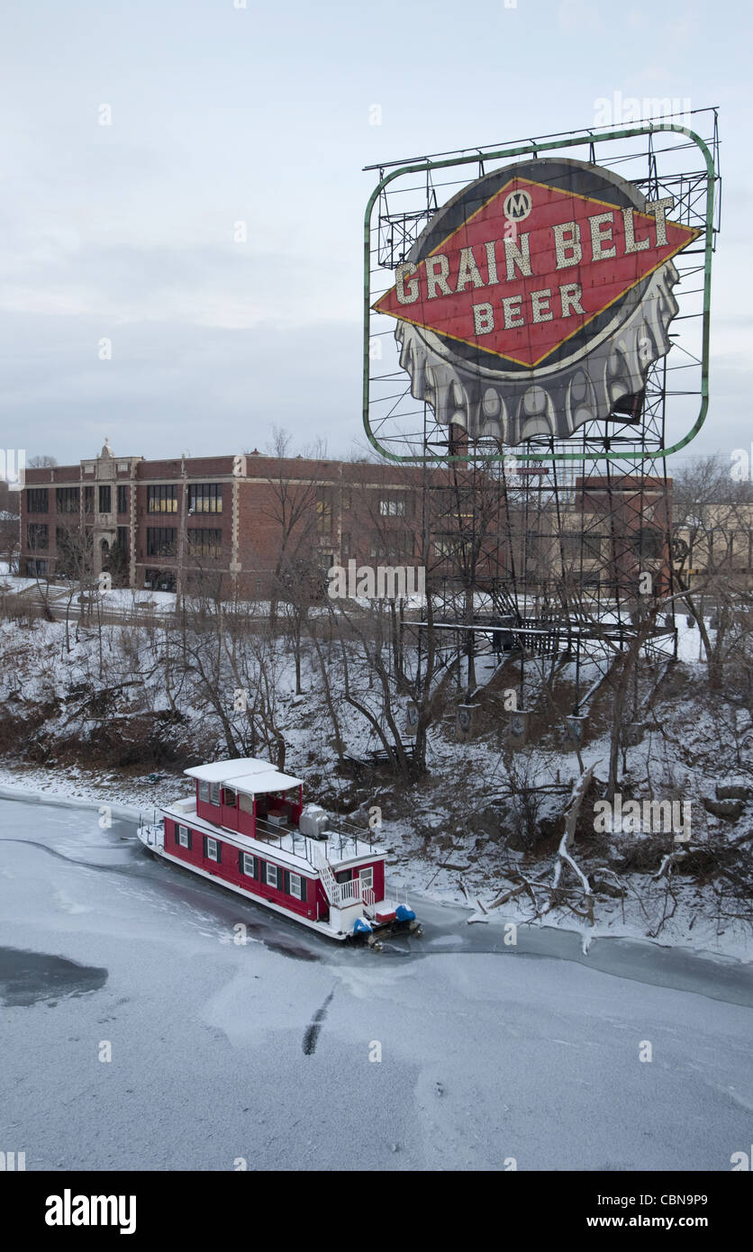 Red houseboat and Grain Belt Beer sign along the Mississippi River in Minneapolis, Minnesota Stock Photo