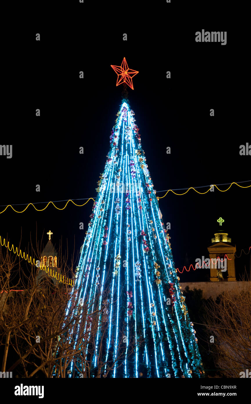 A Christmas tree is flanked by the steeples of Bethlehem's Church of