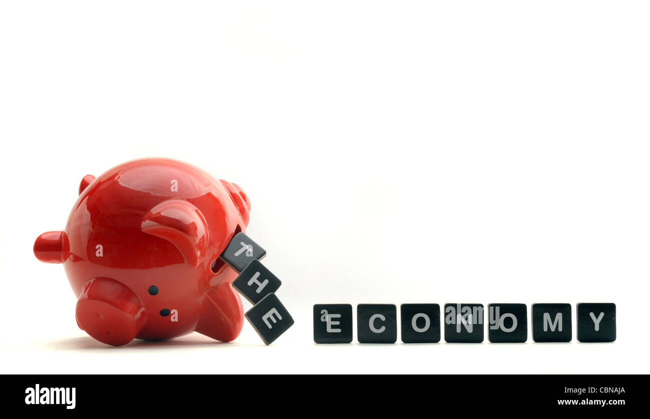 UPTURNED PIGGY BANK SPILLING OUT WORDS SPELLING 'THE ECONOMY' RE ECONOMIC GLOOM RECESSION DOWNTURN CREDIT CRUNCH MONEY ETC UK Stock Photo