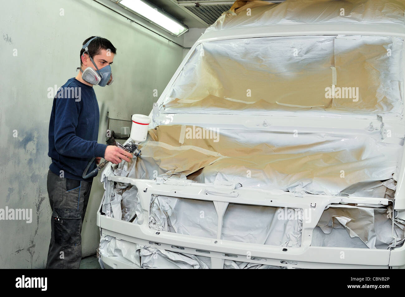 Worker painting a white car Stock Photo - Alamy